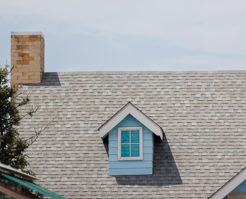 Front view of a home with grey asphalt shingles and blue siding