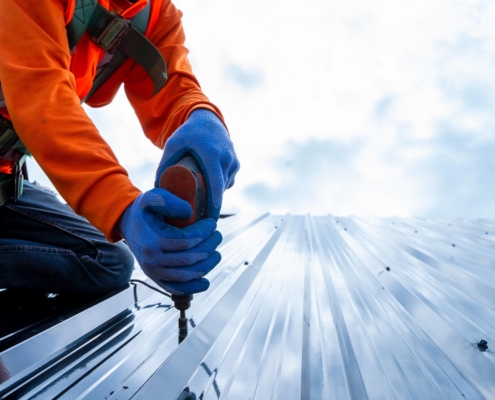 Close up photo of Professional and qualified roofer in protective uniform wear use electric drill to install the m