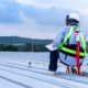 Man wearing full safety body harness working on roof top